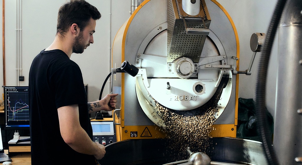 Mistrz palenia kawy przy maszynie do wypalania